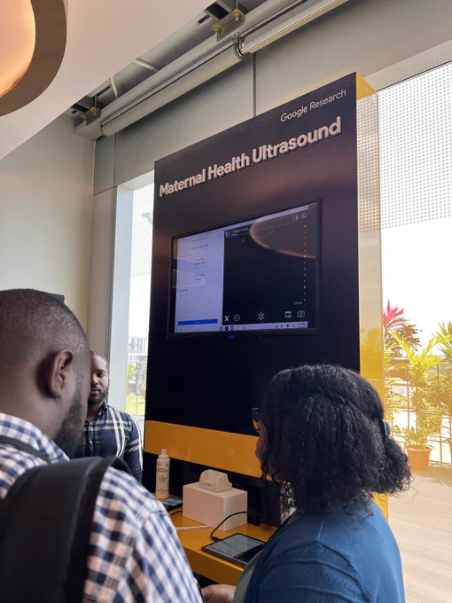 People gather to speak in front of the interactive Maternal Health Ultrasound demo at Research@ Accra.