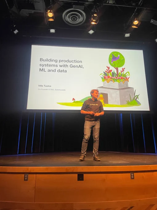 Outerbounds ceo on stage with slide behind him that says building production systems with genAI, ml, and data 