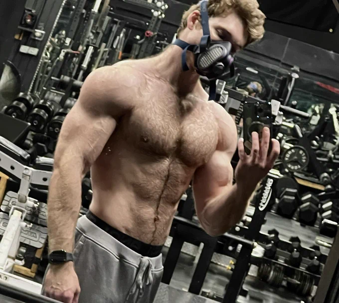 Picture of myself shirtless in an empty gym, pumped and wearing a respirator.