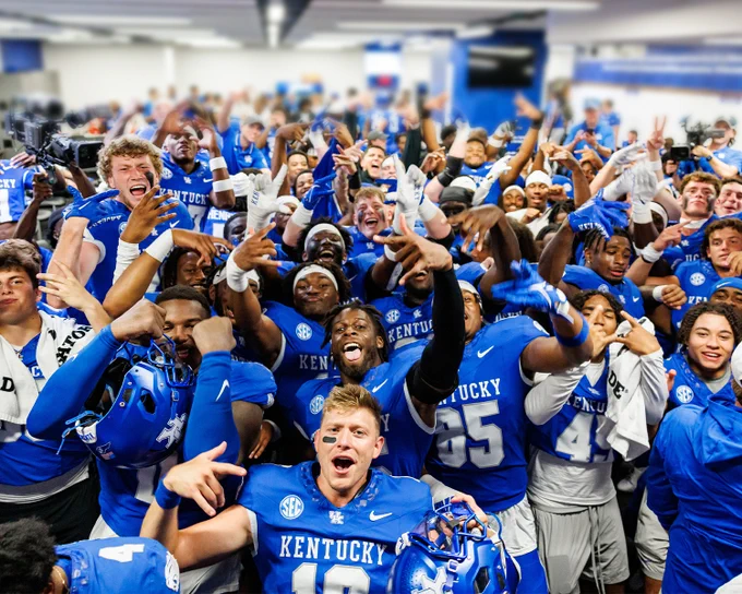Kentucky football players celebrate in the locker room