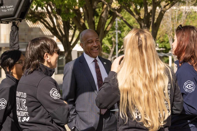 Chancellor May laughing with four team members of Health 34.