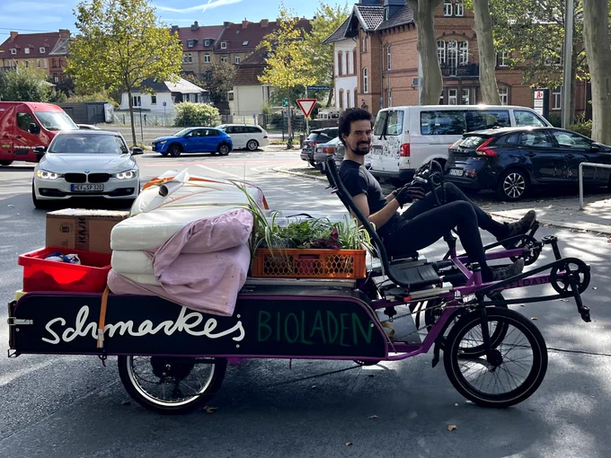 VELOAD mit Schmackes-Aufschrift, voll beladen mit Matratzen und Zimmerpflanzen. 