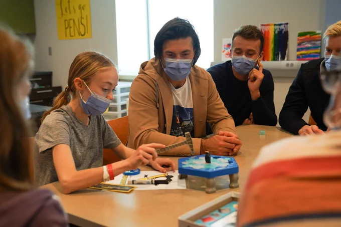 Kris Letang and young woman play a penguin-themed game at the IWK Health Centre.