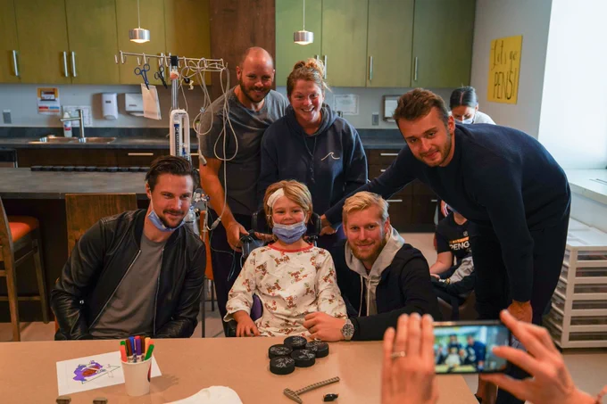 Karlsson, Hellberg, and Zohorna pose with a patient and her family at IWK Health Centre.
