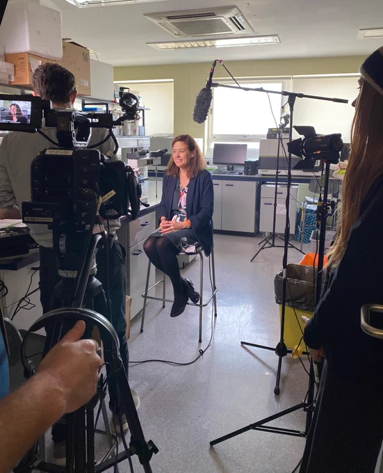 Professor Claire Verrill being interviewed by a camera crew in the lab.