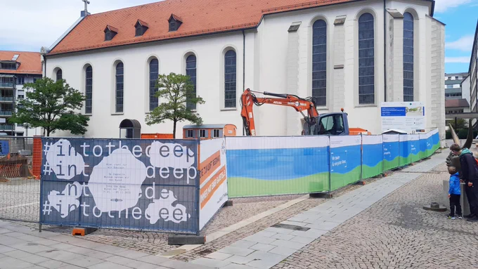 Eine Baustelle mit einem großen Gebäude dahinter.