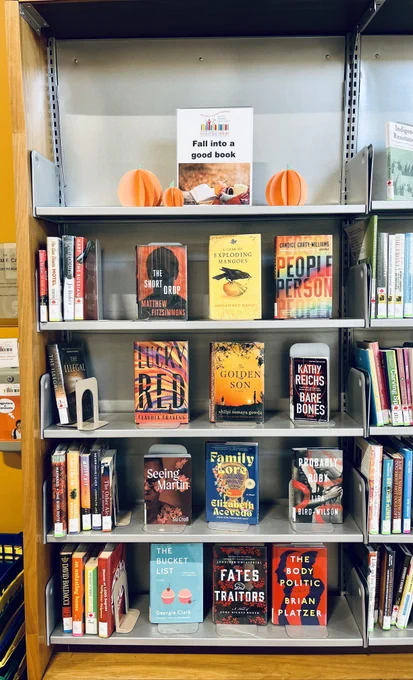 A collection of autumn-coloured books with a sign reading Fall into a good book.