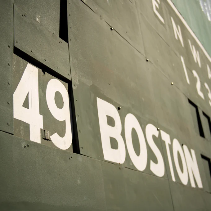 A close-up of the Monster scoreboard shows a 49 number plate slotted in to the board where the day's starting pitcher is typically displayed, alongside the word "Boston."