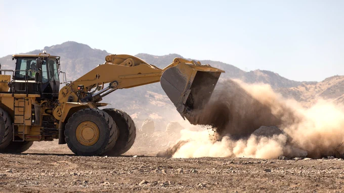 Image of yellow construction truck dumping dirt