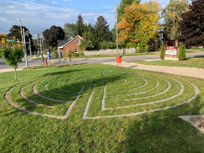 The lines of a labyrinth are set into a lawn using paving stones.