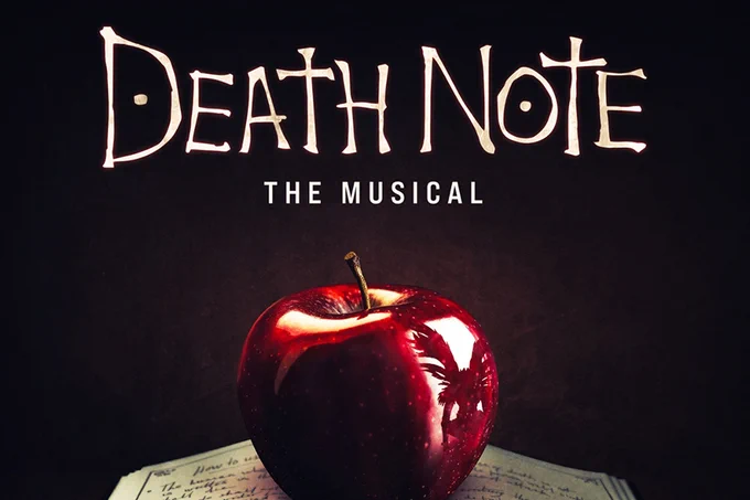 A photo showing artwork for Death Note the Musical, with an apple on top of a book 