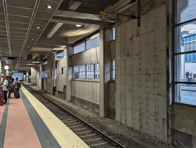 a concrete wall by a train station with lots of shapes 