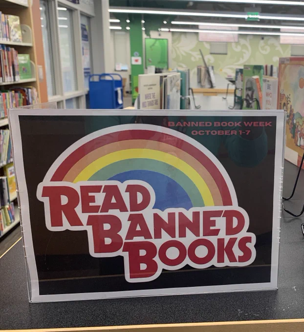 Black sign with a rainbow that reads Read Banned Books