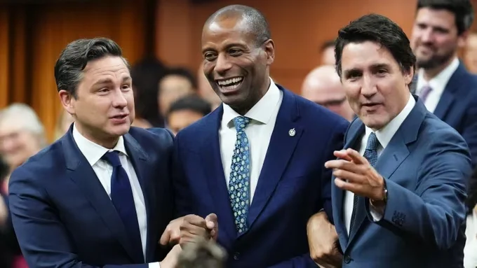 A photo from the linked CBC article, of Pierre Poilievre, Greg Fergus, and Justin Trudeau, arm in arm, smiling, during today's ceremony installing Fergus as Speaker of Canada's House of Commons