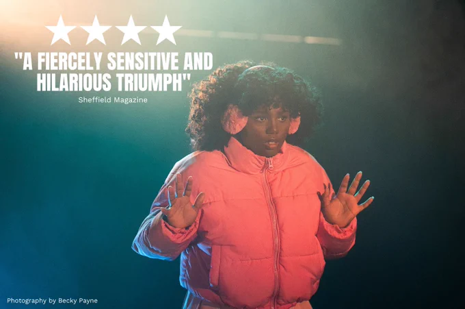 Jada-Li Warrican in We Could All Be Perfect. Photo by Becky Payne. A young woman wearing a pink puffer coat and earmuffs holds their hands up in fear. They are surrounded by green haze. 

Quote on top of image reads FOUR STARS "A FIERCELY SENSITIVE AND HILARIOUS TRIUMPH" (Sheffield Magazine)