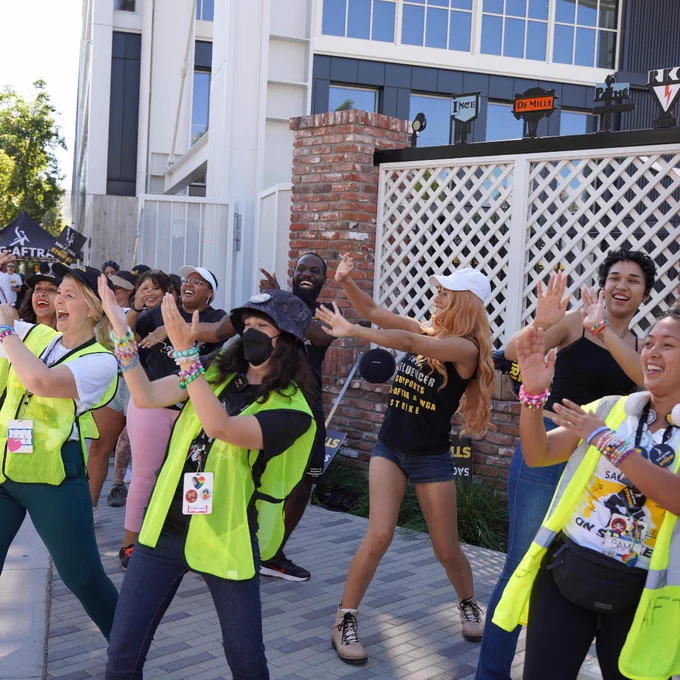 Multiple influencers and strike captains doing a dance on the picket line.
