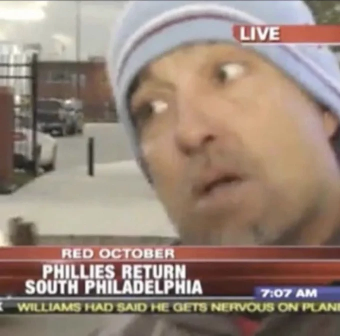 SAID guy looking off to the side with the headline being "RED OCTOBER: PHILLIES RETURN TO SOUTH PHILADELPHIA" on the TV.