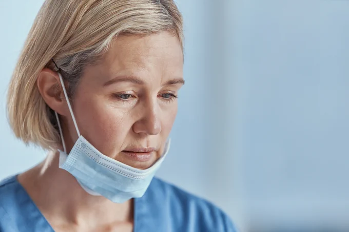 When medical work costs you your mental health: photo of a mature doctor looking unhappy 