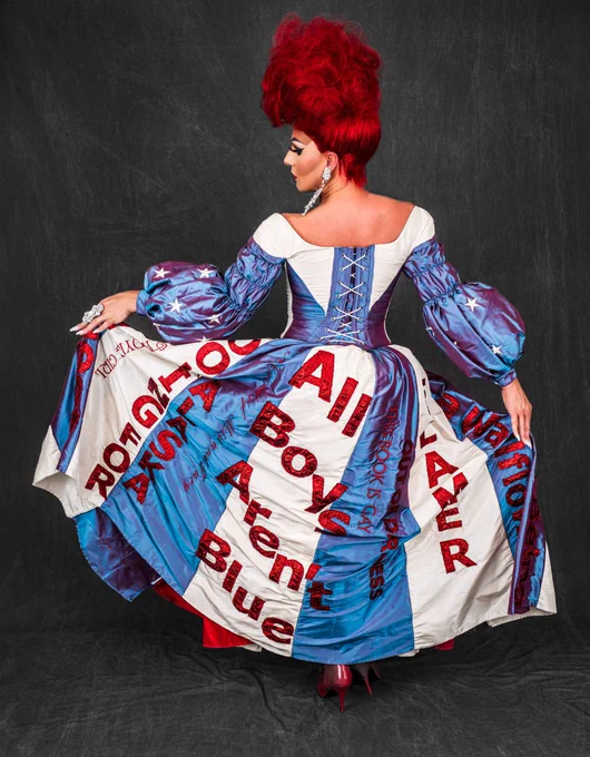 Gia posing in the Let Freedom Read dress. Several book titles are displayed. Gia is looking over her shoulder with her back facing us. 