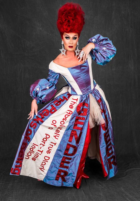 Gia is posing with the dress extended so several titles can be read such as The Absolutely True Diary of a Part-Time Indian, Gender, Queer, and The Perks of Being a Wall Flower. 