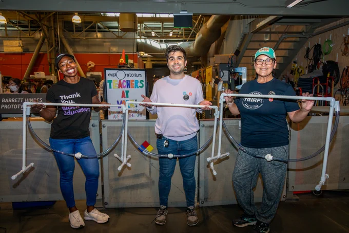 Three teachers proudly showing of their created exhibit