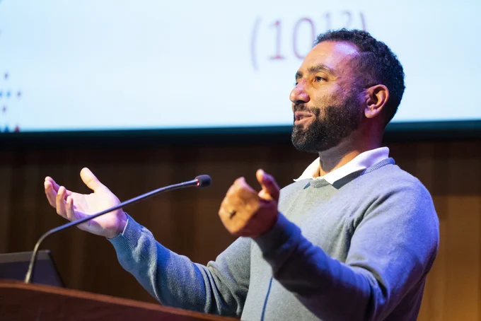 Professor Aaron Streets speaks into a microphone at a podium. (Photo by Adam Lau / Berkeley Engineering)