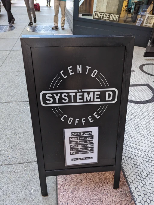 A-frame sign that says "Cento Système D Coffee" in downtown San Francisco.