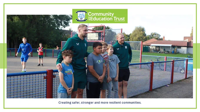Preston North End players Patrick Bauer (left) and Dai Cornell pose for a photo with PNECET Premier League Kicks participants at Moss Side. 