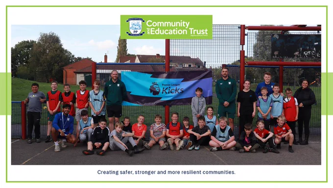 Preston North End players Patrick Bauer and Dai Cornell pose for a photo with PNECET Premier League Kicks participants and staff at Moss Side. 