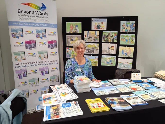 A photo of Irene Tuffrey-Wijne at a conference table covered in Beyond Words resources.