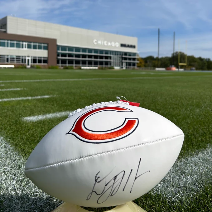 Signed DJ Moore football with Bears practice field in the background
