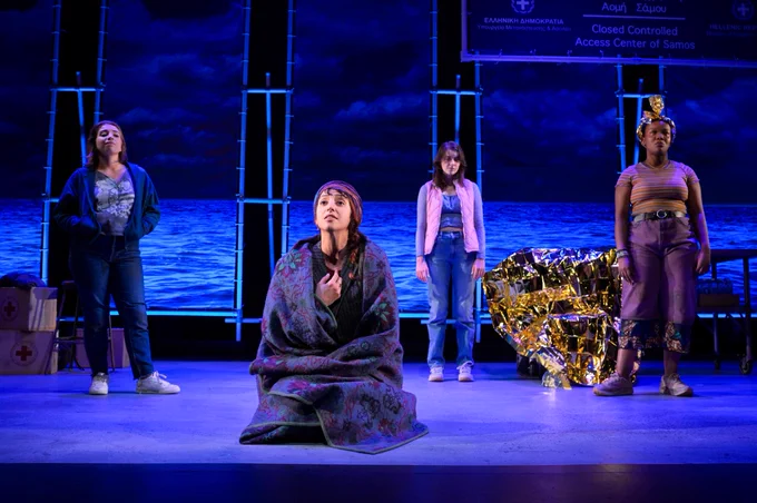 4 actors performing on a dimly lit stage. The person towards the front is singing. 