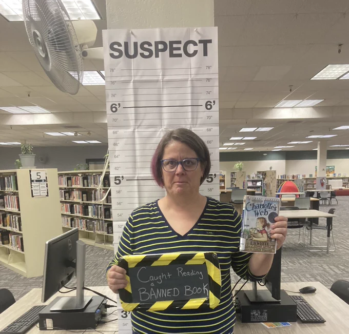 Photo one shows the Sierra View Library Branch Manager posing with Charlotte's Web, a frequently challenged title. 