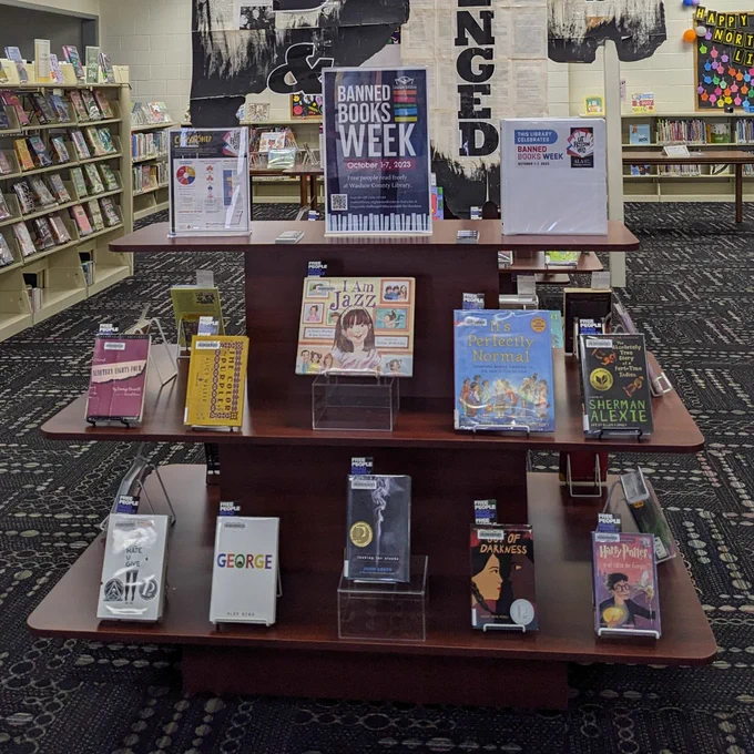 Photo four shows a close-up of the display at the North Valleys Library and the books available for checkout.