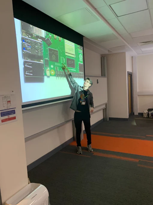 Sam pointing to Raspberry Pi board on display