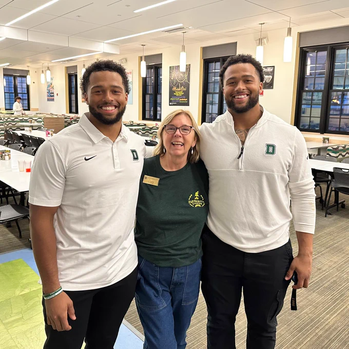 Here’s an image of two Dartmouth football players posing for a photo with Deb.