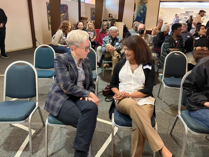 Governor Tina Kotek and Commissioner Susheela Jayapal are sitting and talking to each other at a celebration for the Portsmouth Commons. 
