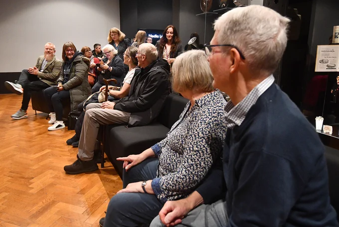 A group of people seated in conversation and laughing with each other.