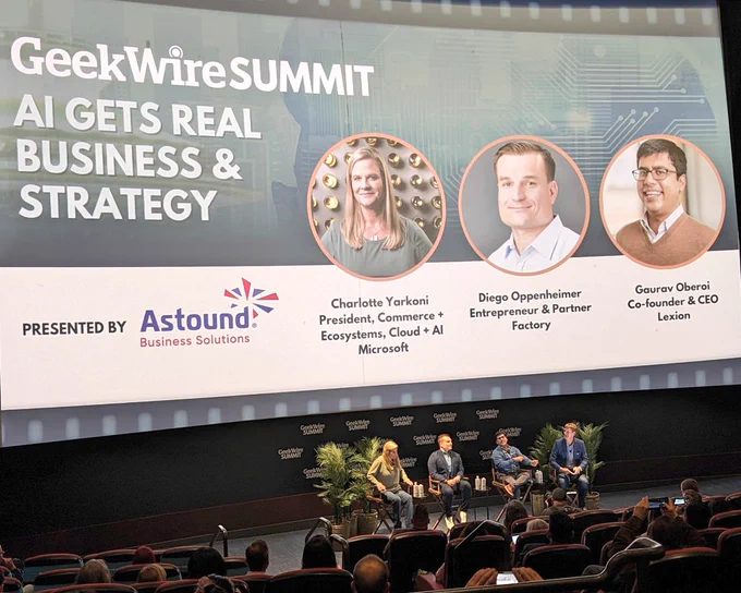 Wide photo of the former Cinerama theatre during the AI Gets Real business and strategy summit presented by Astound Business Solutions during the #GeekwireSummit at SIFF cinema Downtown Seattle... four speakers on stage left to eight Charlotte Yarkoni of Miceoaoft, Diego Oppenheimer of Factory, Gaurav Oberoi of Lexion and panel moderator John Cook, Co-Founder of GeekWire.