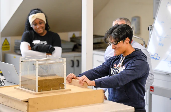 Two students working with equipment in an engineering lab.
