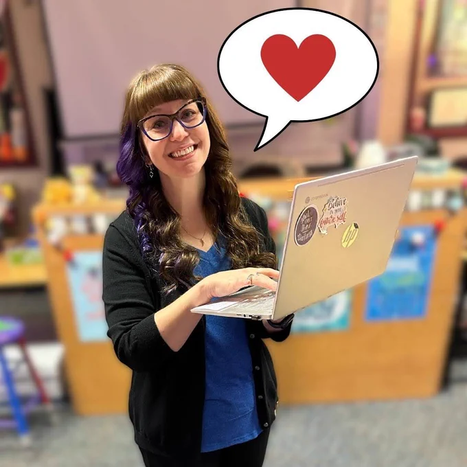 Mrs. Karpiuk with a Chromebook and a graphic of a speech bubble with a heart in it.