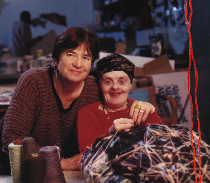 In an art studio, Judith Scott and her twin Joyce smile while Judith works on one of her sculptures

Image Source: TheAtlantic.com