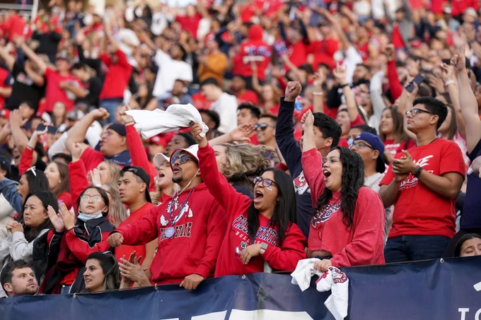 Fresno State fans in Bulldog red cheer on the Fresno State football team
