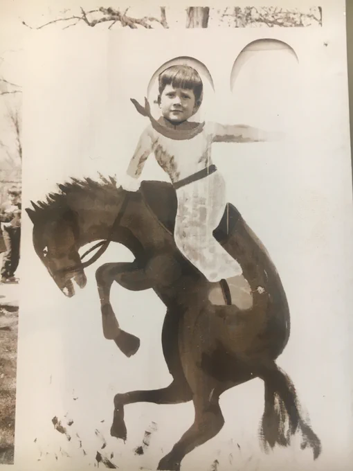 A young boy putting his head in a photo stand-in. It looks like he is riding a horse. 