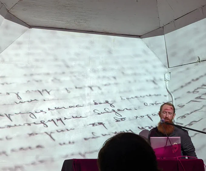 Jordan Magnuson, with a projection of handwritten text