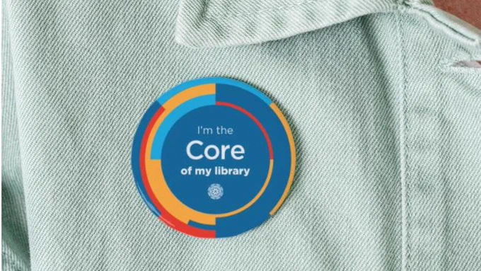 A close up photo of a jean shirt with a Core pin reading, "I'm the Core of my library."
