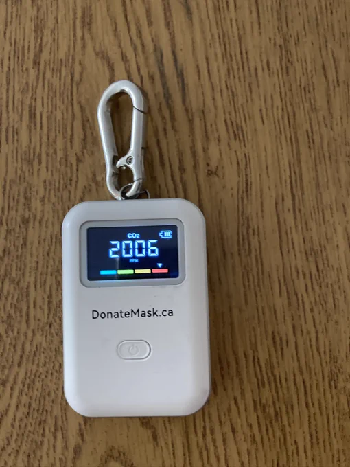 A photograph of a CO2 Vitalight monitor from DonateMask.ca displaying a reading of 2006 ppm and an arrow pointing to the red zone.