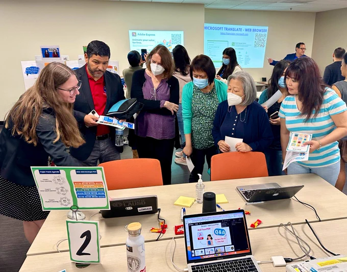 Photo of coach demonstrating a tool to a group of interested educators.