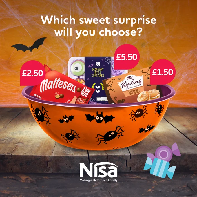 Orange bowl decorated with bats and spiders. The bowl is full of sweet treats including malteasers and cupcakes. 