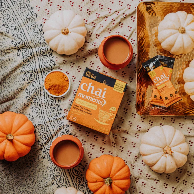 A box of Instant Chai Latte next to pumpkins